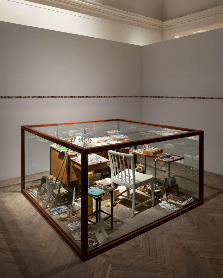 glasmonstre med genstande i: stole, borde etc