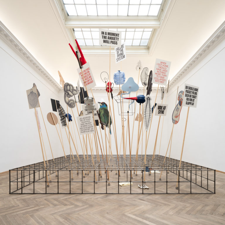 demonstrationsskilte der er placeret på et fundament bestående af et jerngitter