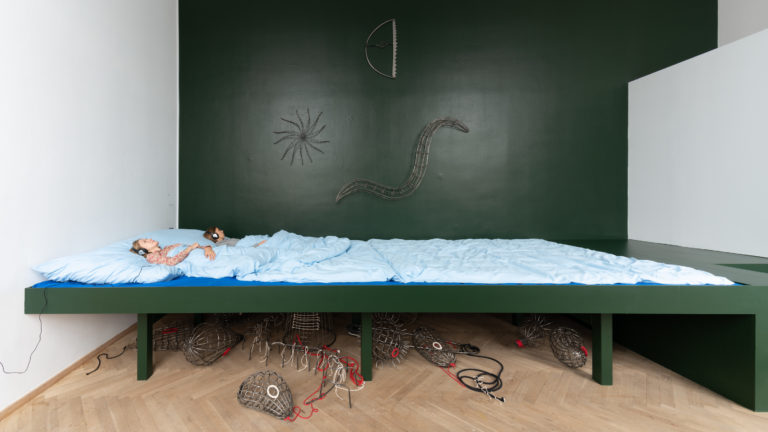 kæmpe barneseng, så stor man man som voksen bliver lille/bliver væk i sengen når man ligger i den. man kan ligge i sengen og høre voice over af børn der fortæller om deres drømme