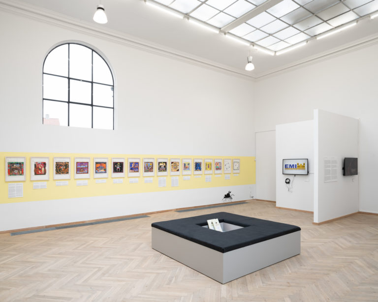 installationsbillede af mange små værker der hænger på væg