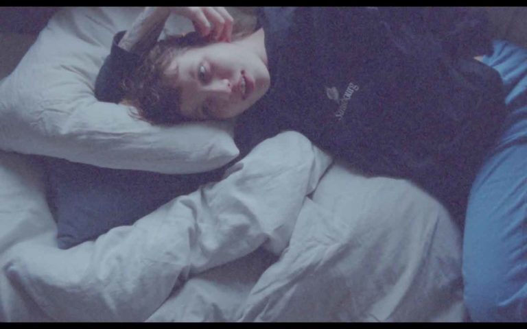 Still fra film af kvinde der ligger i en seng.
