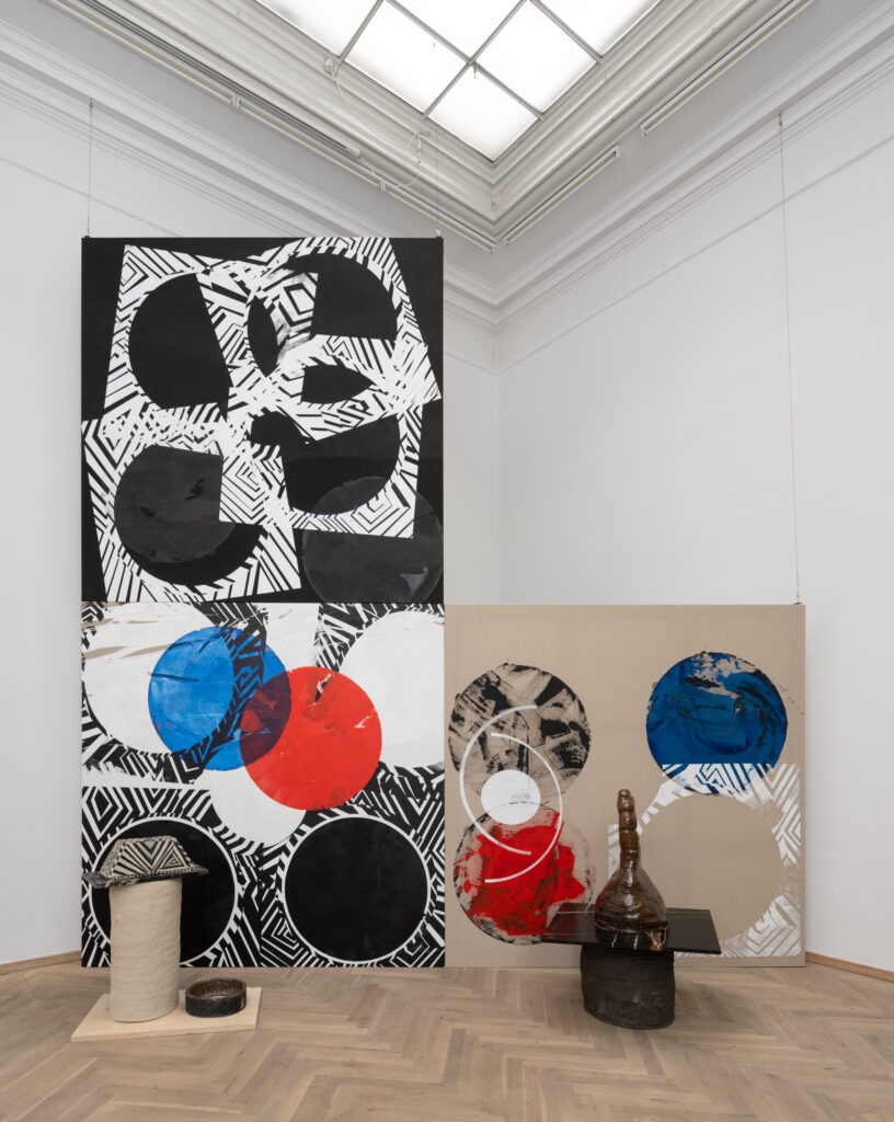 A collection of works in blue and red tones in an exhibition space.