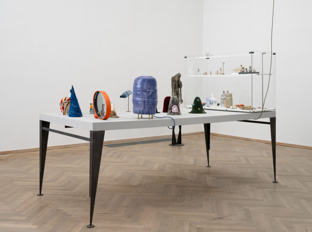 Table with various sculptures and vases, in different sizes.