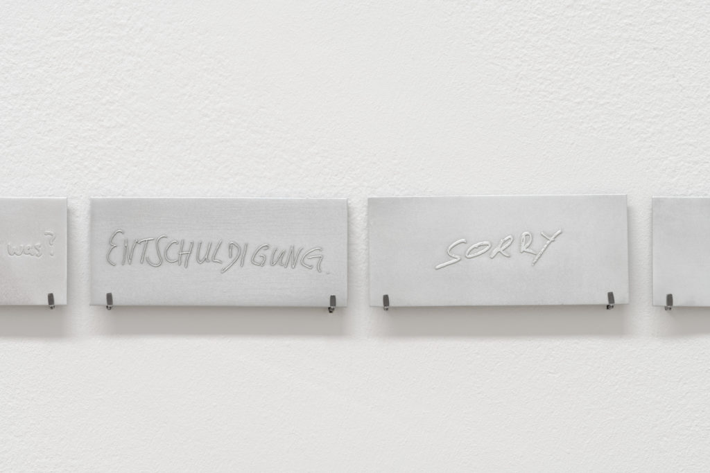 Plates with text, hung on the wall.