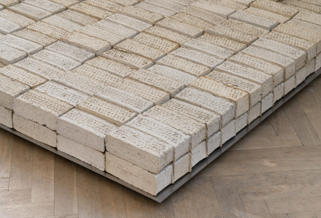 Stacked bricks on a podium.