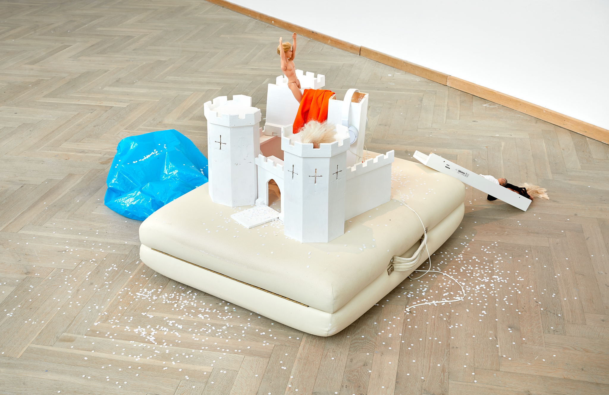 Sculpture consisting of a castle and Barbie dolls.