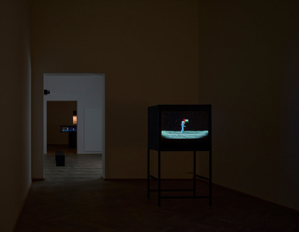 A TV screen in a dark exhibition space.